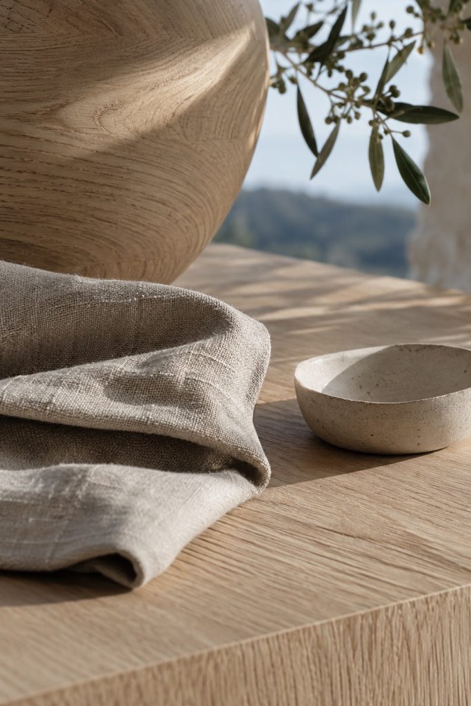 A close material study of pale oak grain, oat linen and chalk ceramic.